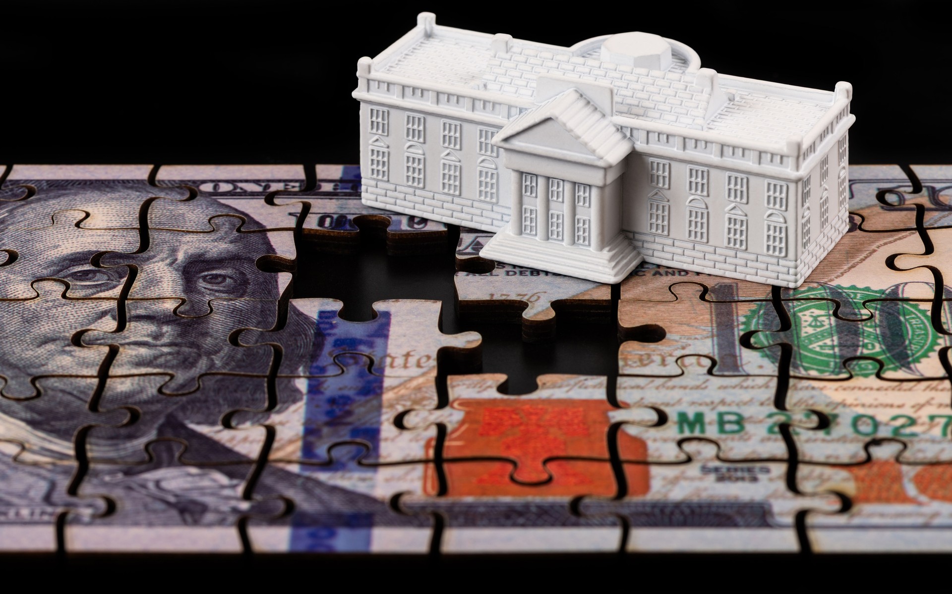 The symbolic residence of the President of the United States, the White House, and a 100 US dollar bill assembled from puzzles.